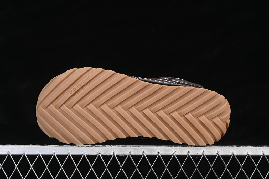 Underside of the sneaker showing a tan outsole with a herringbone-style tread.