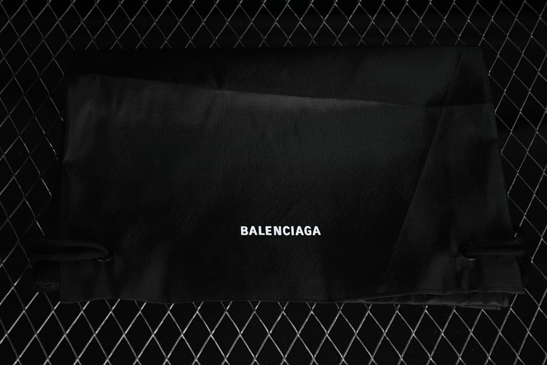 Black branded fabric bag photographed with the sneaker