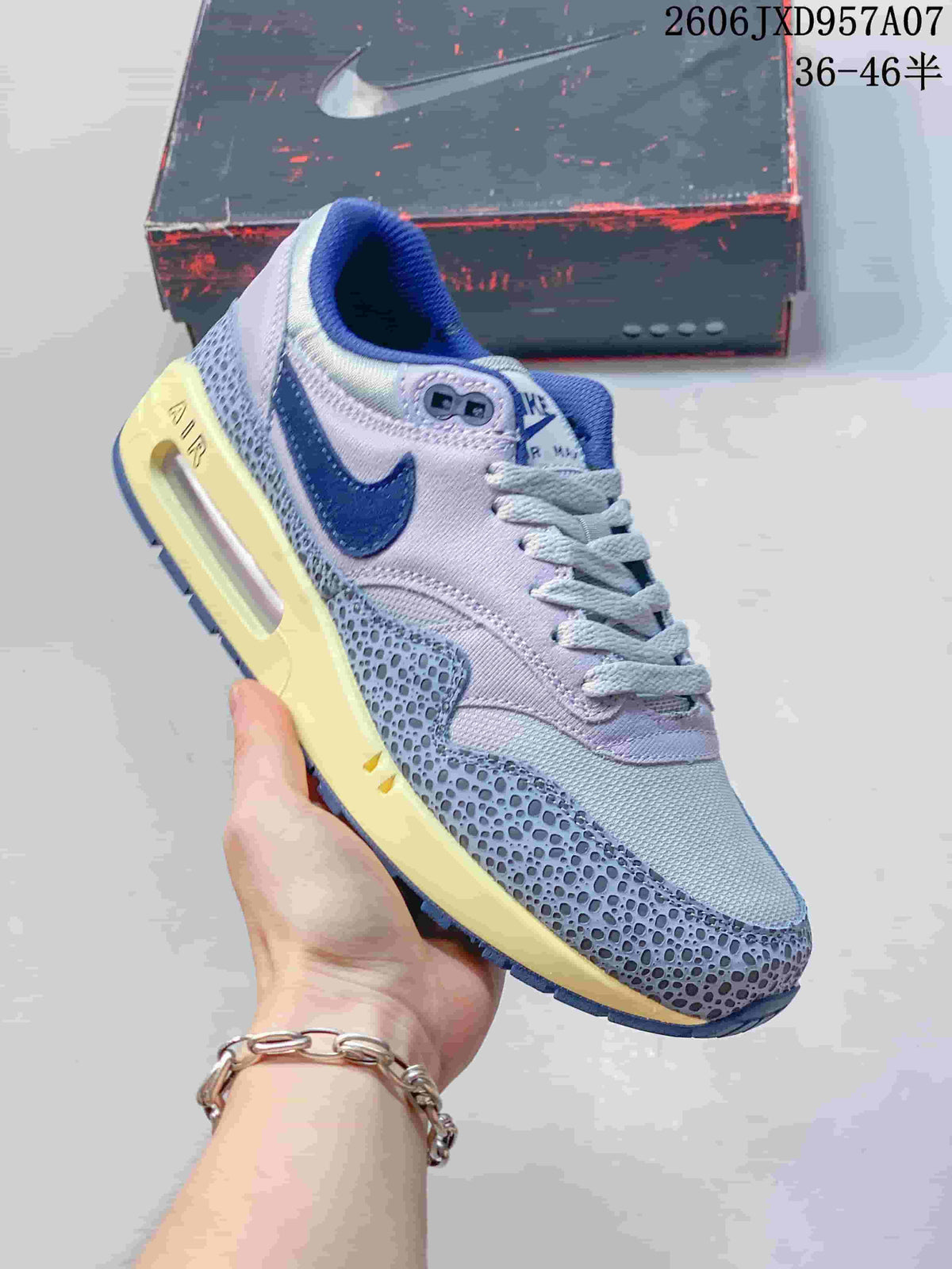 Angled side view of the Nike Air Max 1 '86 Premium sneaker in gray-lavender, blue, and cream.