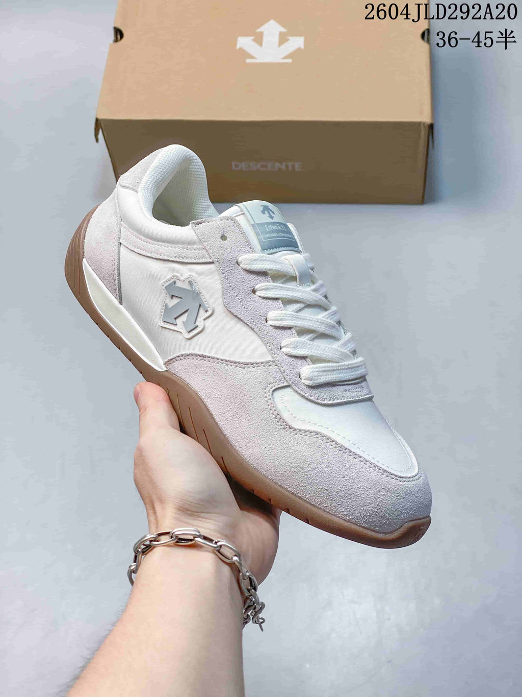 Side view of a pale gray and white Descente Chron Tempo Slim sneaker with a gum-tone outsole.