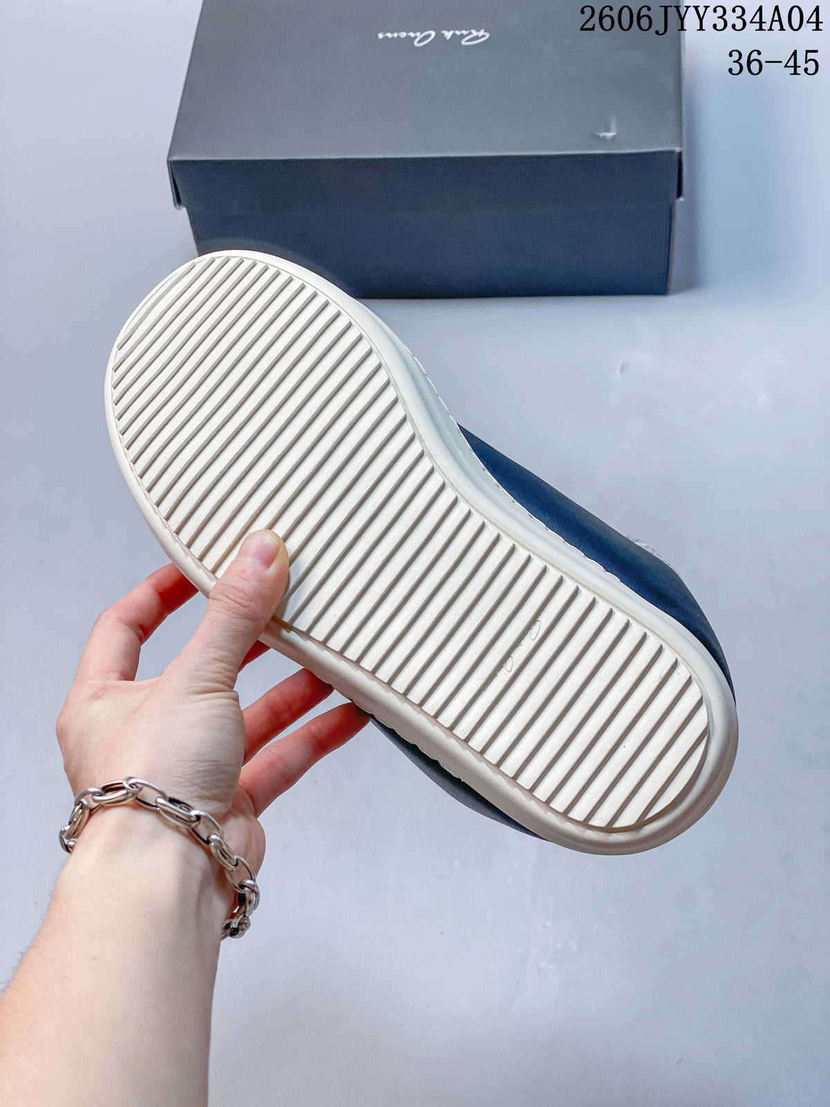 View of the ivory ribbed outsole on a navy low-top sneaker