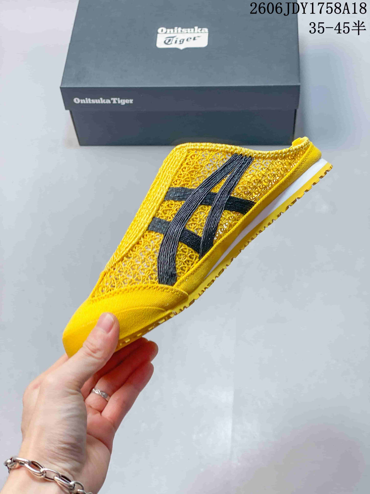 Side view of the yellow sneaker with dark stripes and an open-back sabot shape