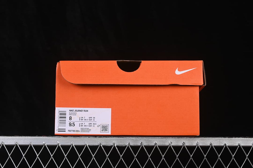 Orange shoe box with a label identifying Nike Journey Run, black and white, and FB7765-004