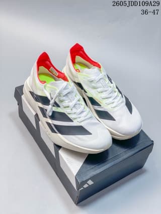 Pair of white Adidas running shoes displayed on an Adidas shoe box, with black stripes and red accents visible.
