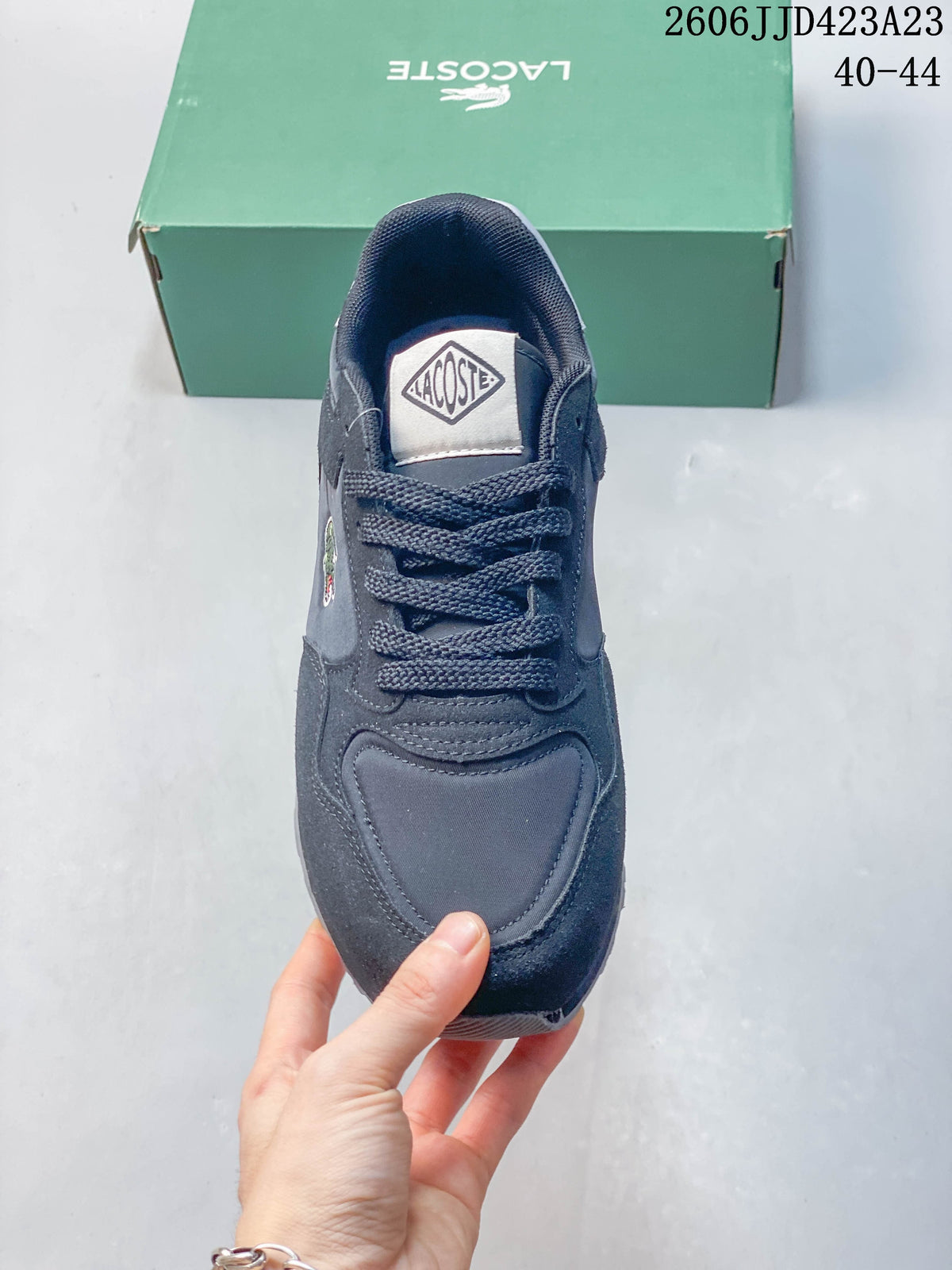Top view of a navy lace-up sneaker with a branded tongue patch.