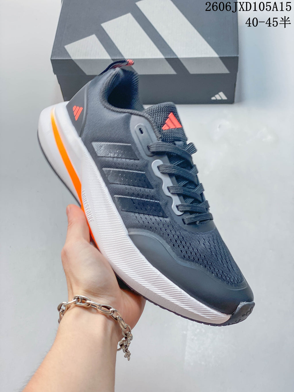 Side view of a charcoal-gray Adidas Ultrabounce shoe with coral heel accent