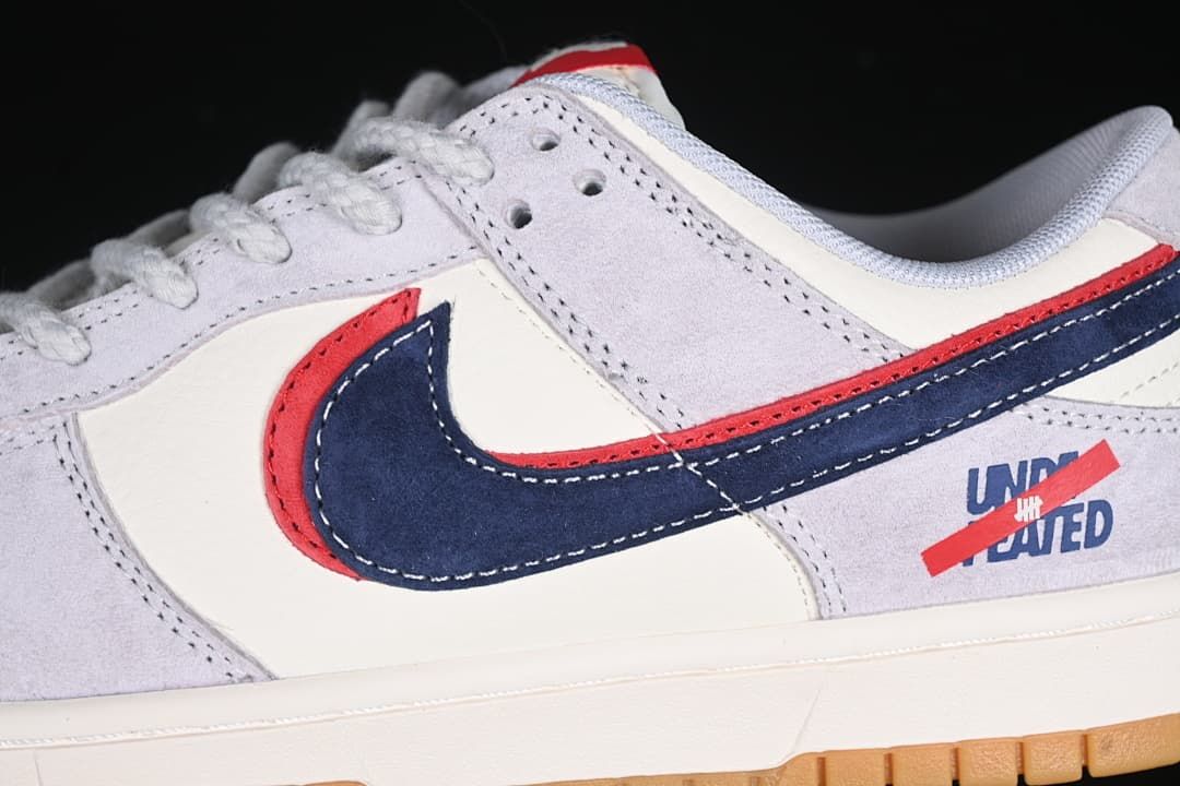 Close-up of the navy Swoosh layered over a red accent and Undefeated heel graphic.