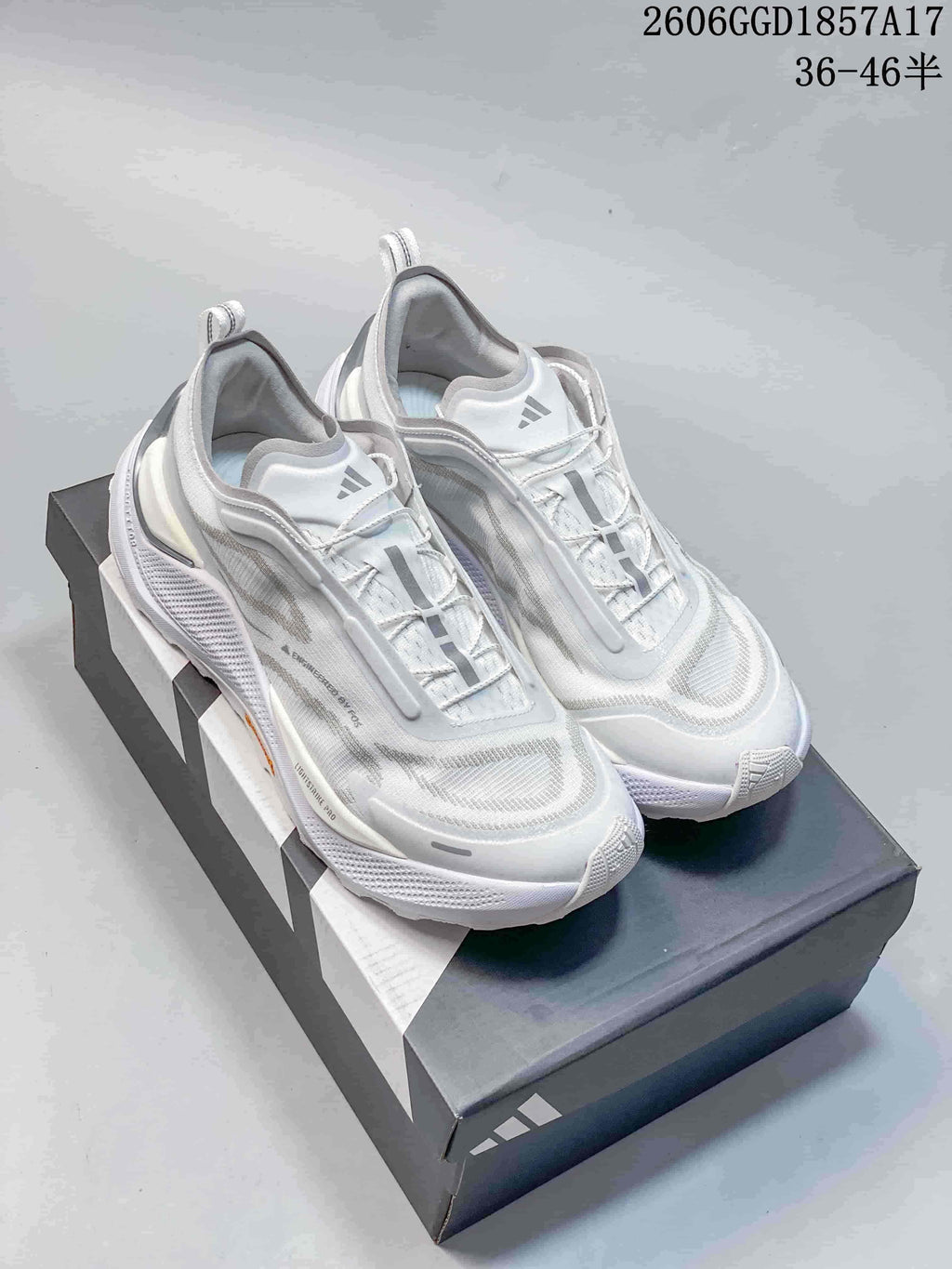 Pair of white adidas HOLO PEAK trail shoes on a shoebox.