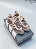 Pair of brown and cream Adidas Originals VS JOG 2.0 sneakers displayed on a shoebox
