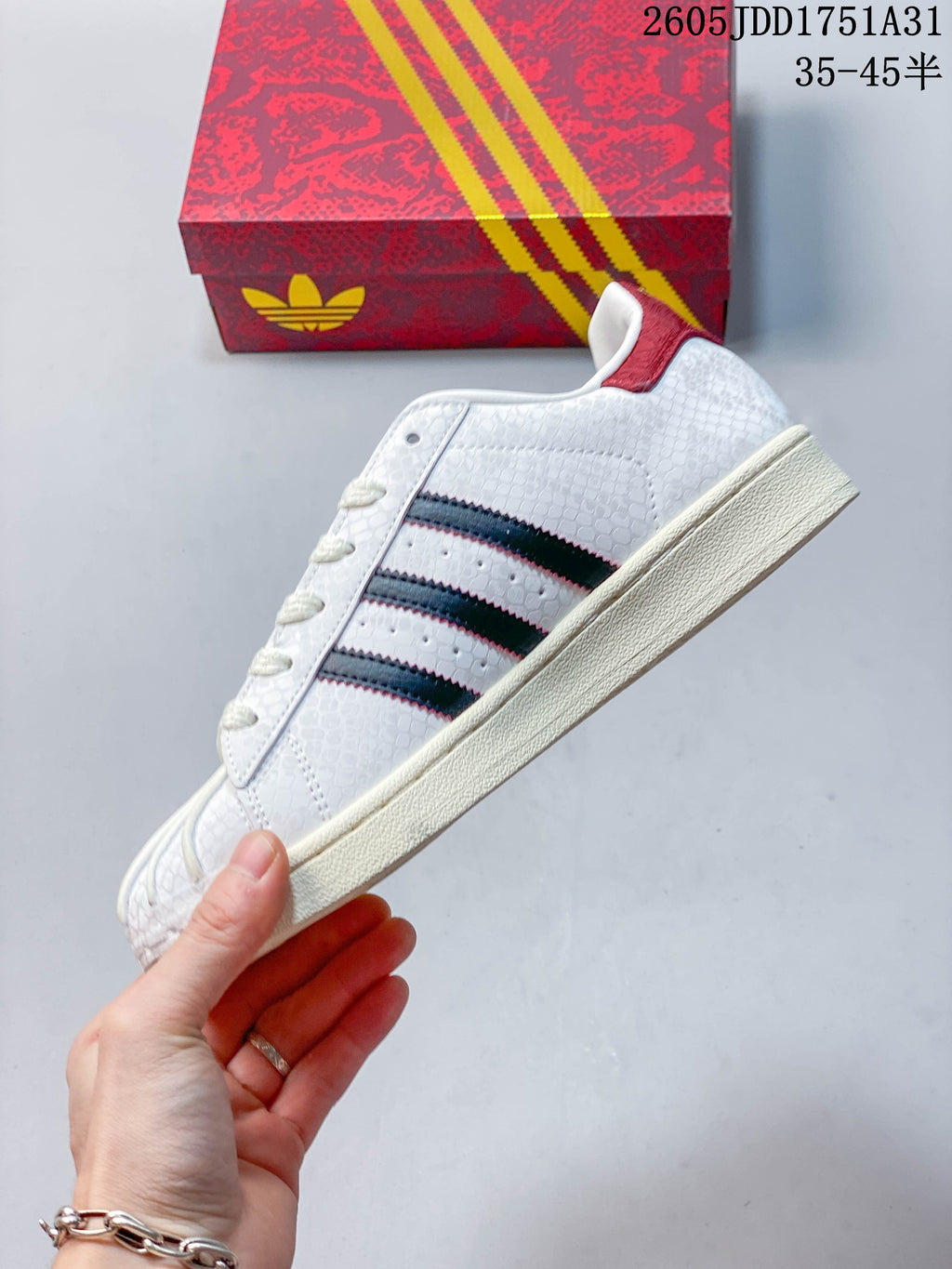 Side view showing the dark stripes, textured upper, and cream-colored sole