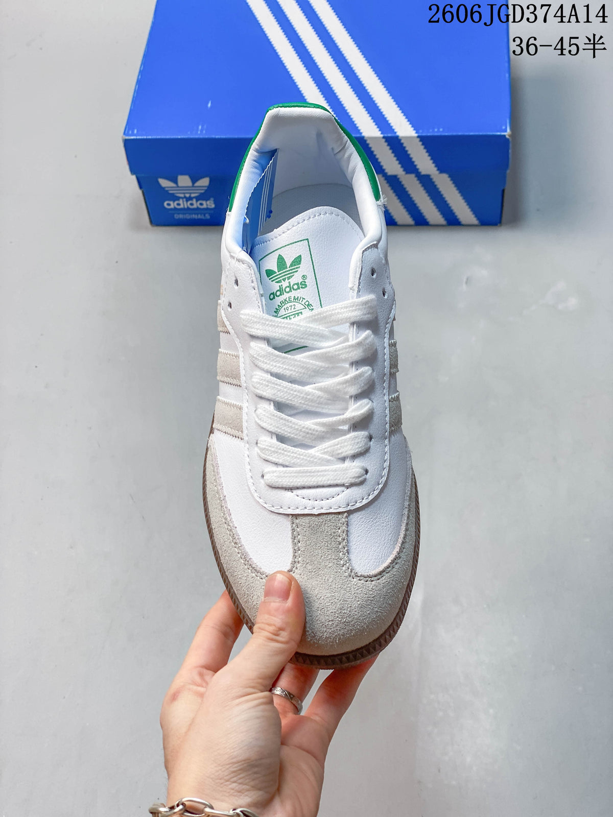 Top view of a lace-up white sneaker with gray toe overlays and a green tongue label.
