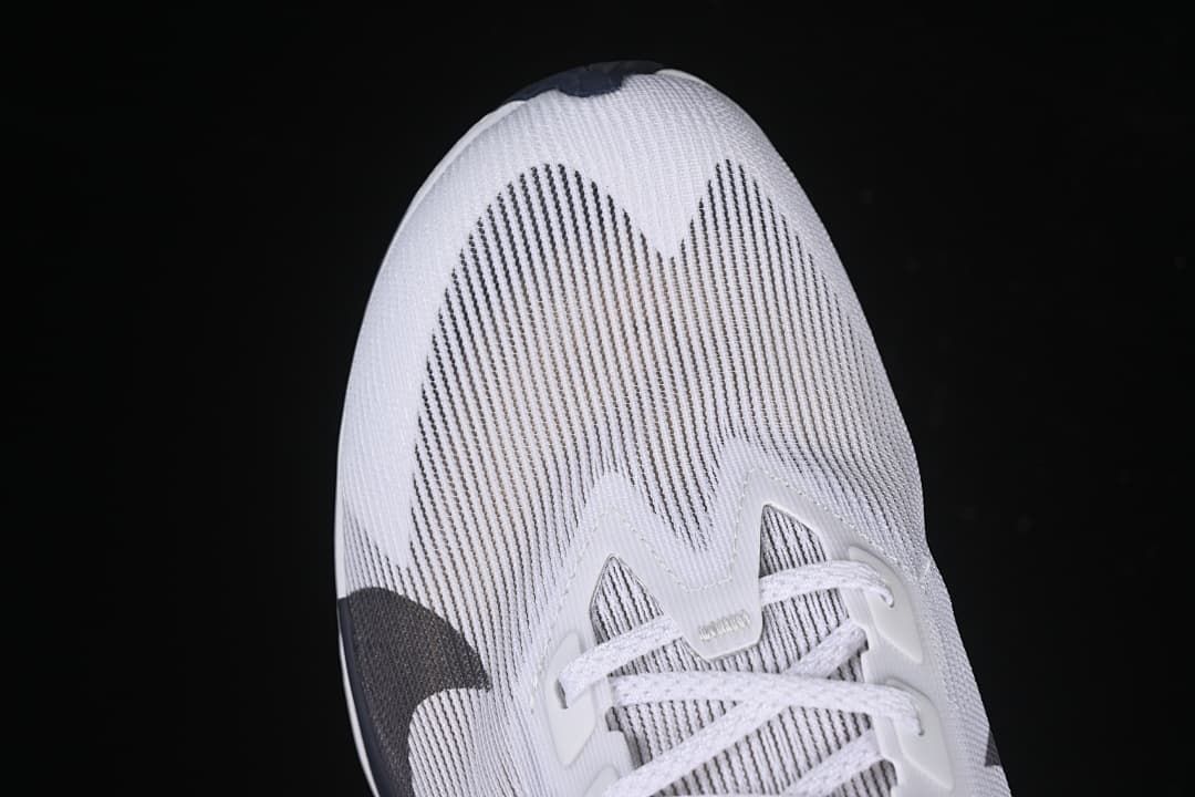 Top view of the toe area with linear dark detailing on the white upper.