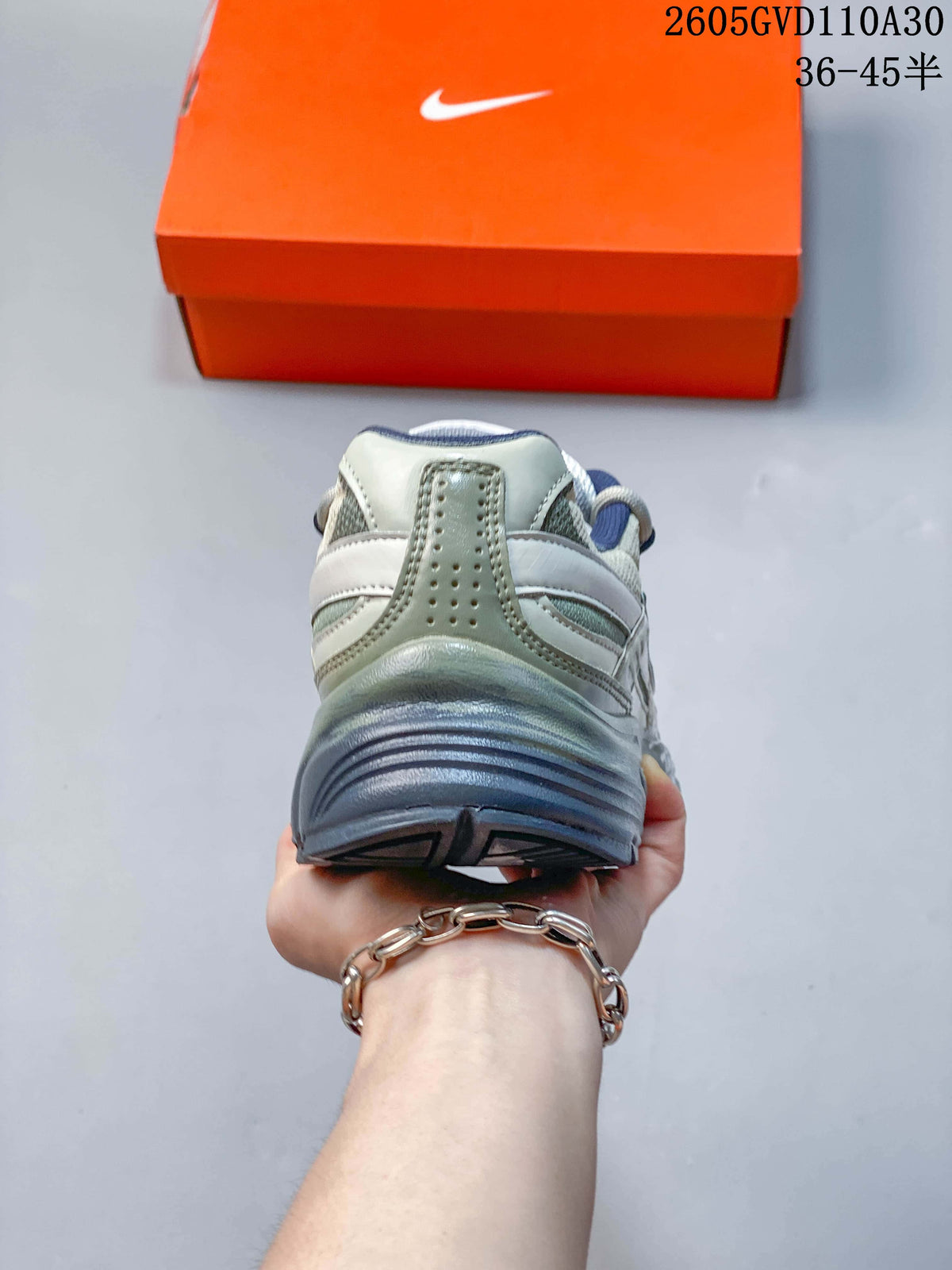 Rear view of a Nike Initiator sneaker showing the blue-gray heel and layered upper
