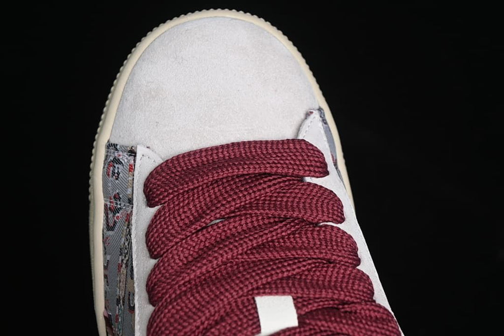 Top view of the light-colored toe panel and burgundy laces