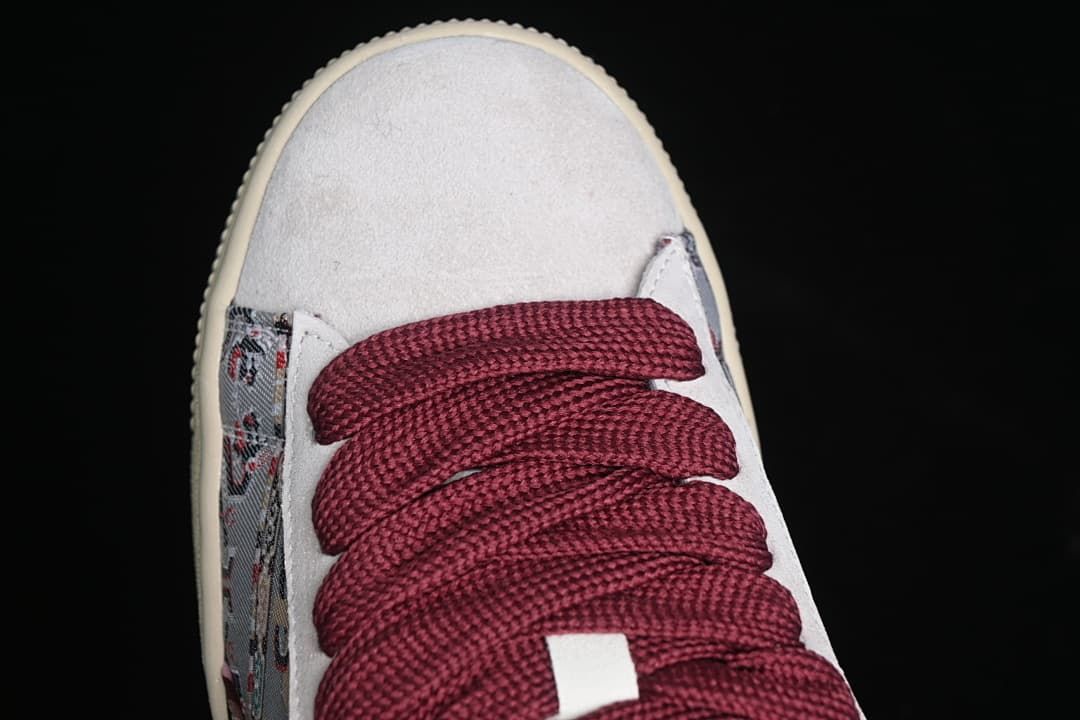 Top view of the light-colored toe panel and burgundy laces