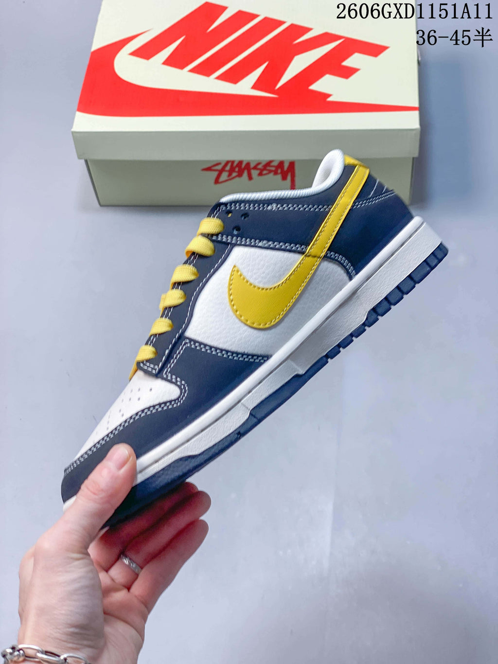 Side profile of a navy, off-white and yellow low-top sneaker