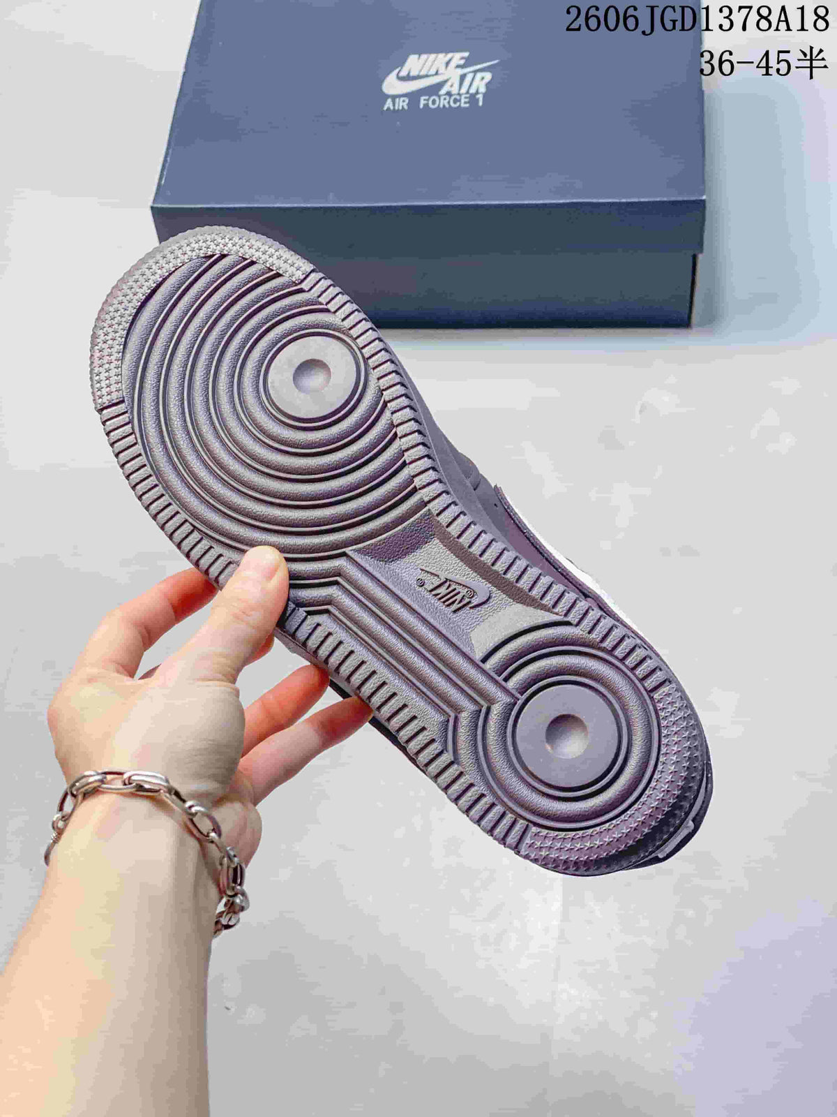 Close-up of the ridged outsole on a mauve Air Force 1 sneaker.