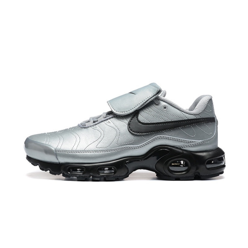 Silver Nike Air Max Plus sneaker with a black swoosh and strap across the upper.