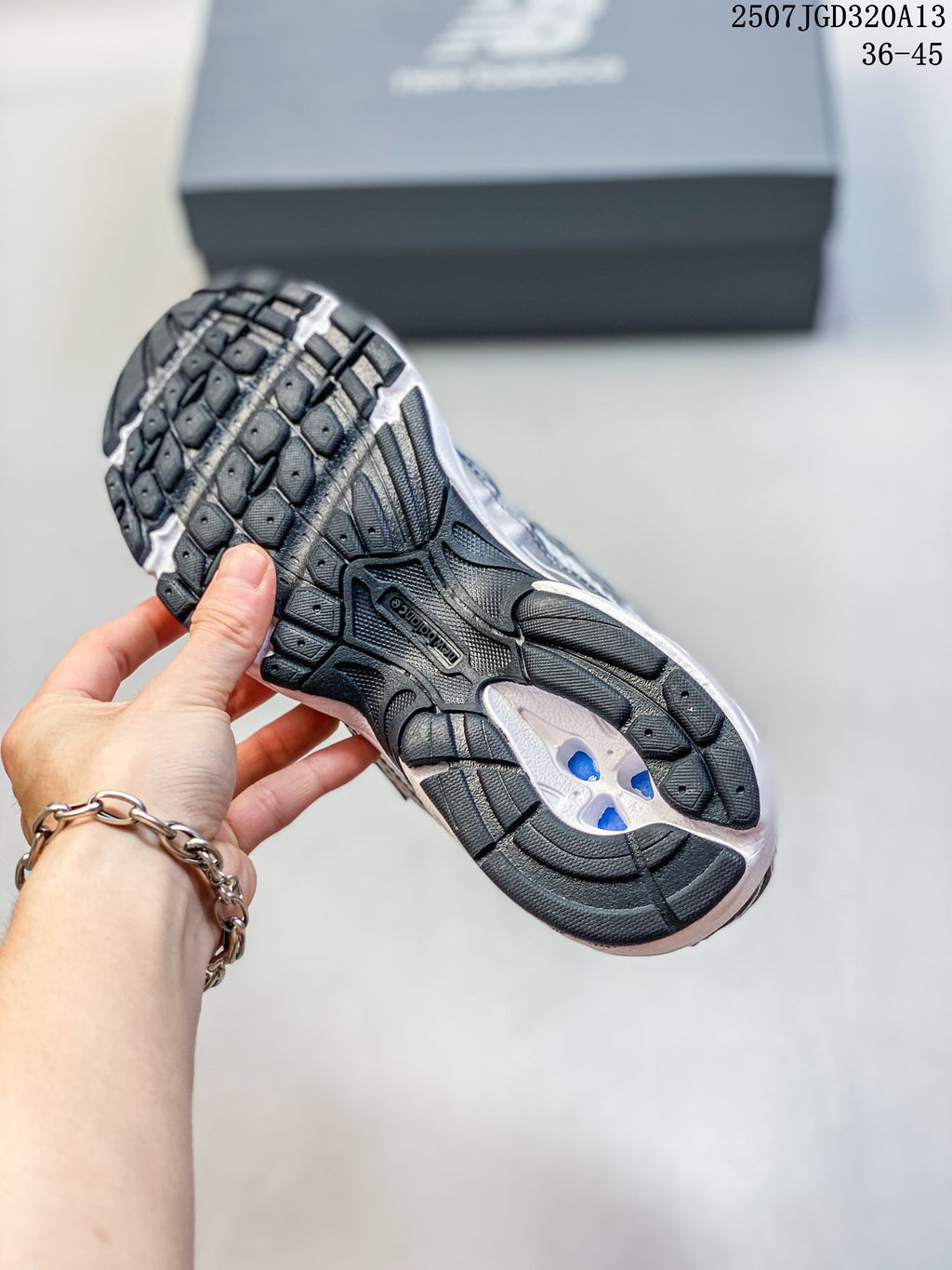 Underside view of the sneaker showing its dark patterned outsole and white midsole.