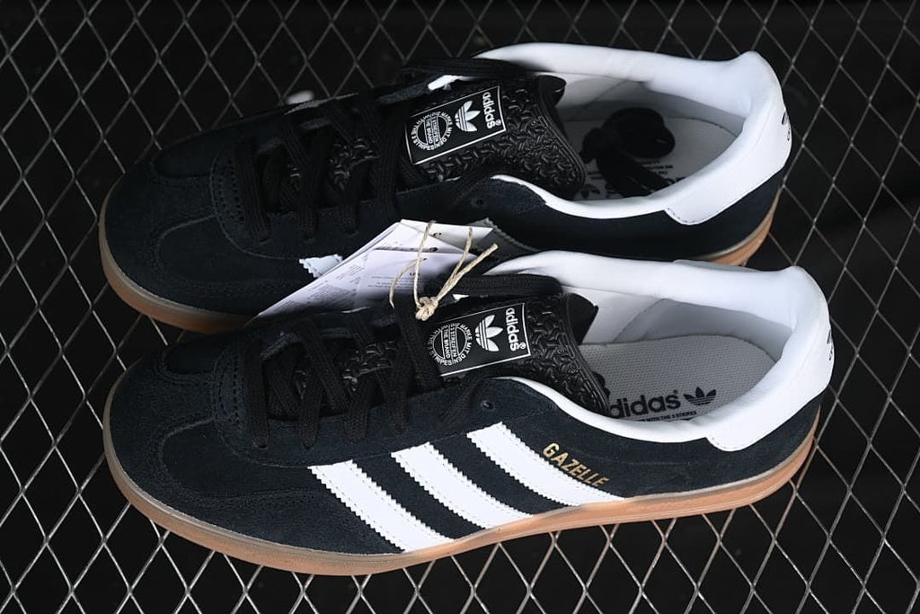 Pair of black and white Gazelle Indoor sneakers viewed from above at an angle.