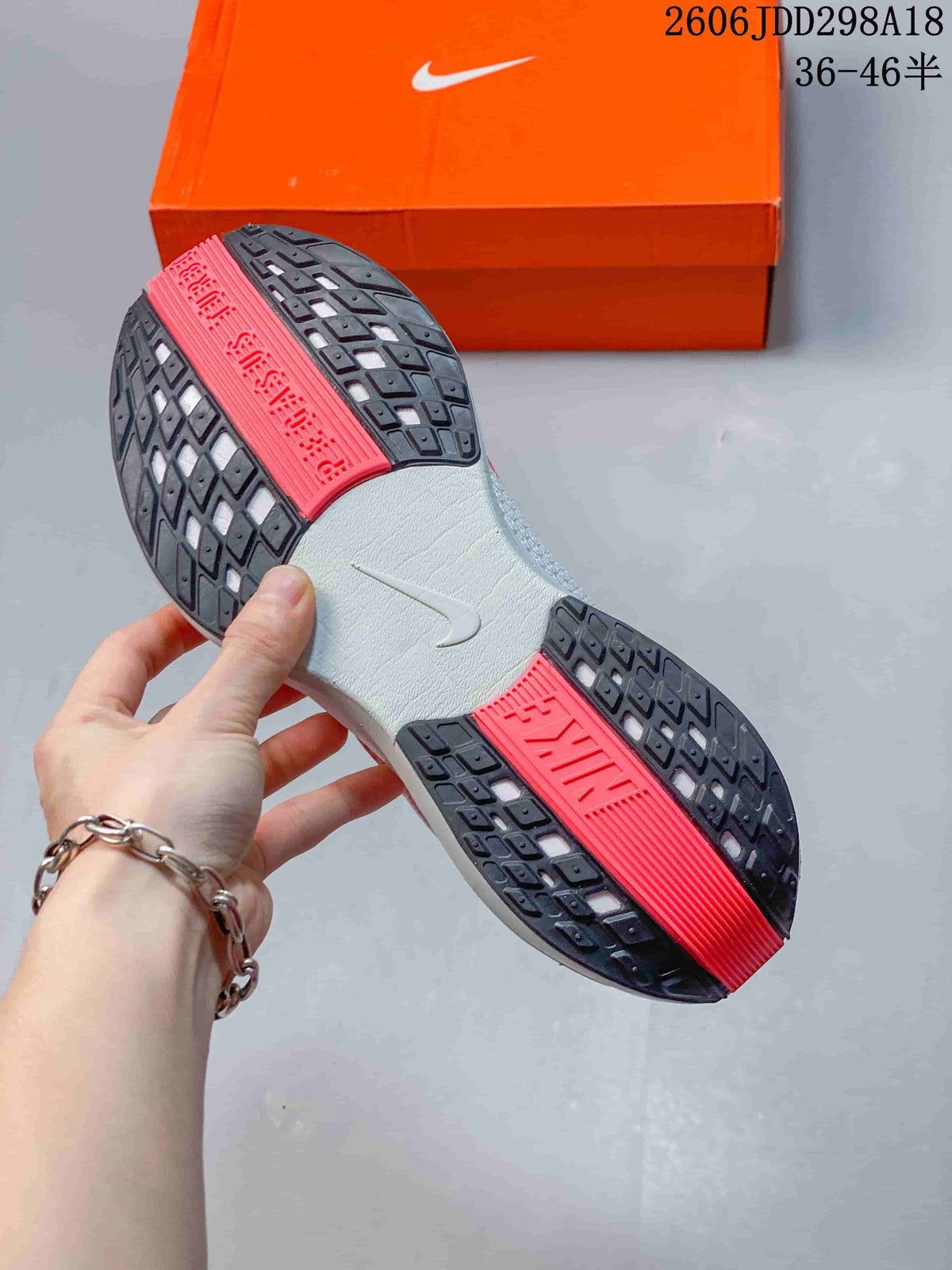 Outsole view showing dark tread sections and coral-colored center panels