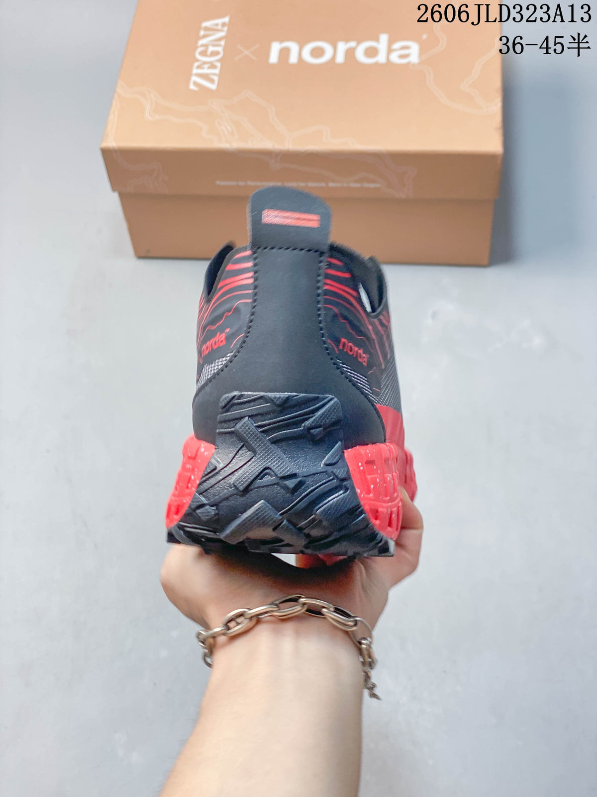 Rear view of a charcoal and red Norda shoe