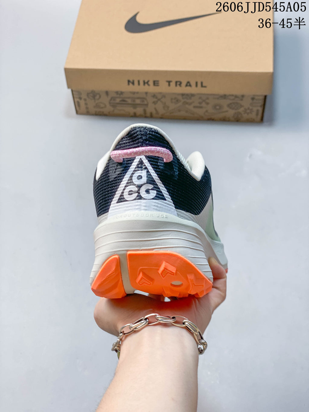 Rear view of a Nike ACG Pegasus Trail 6 shoe showing the heel and orange outsole.