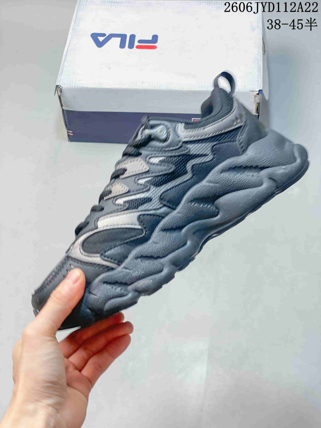 Side view of a gray FILA sneaker with layered panels and a chunky sole