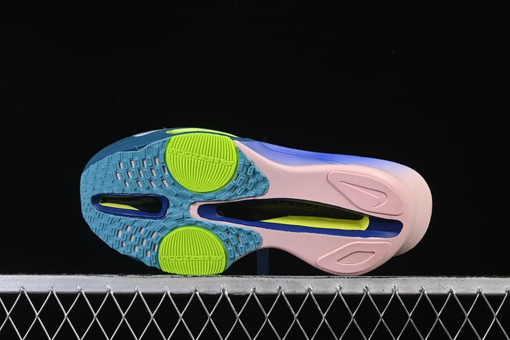 Underside view showing patterned blue outsole sections, lime circular details, and a central channel.