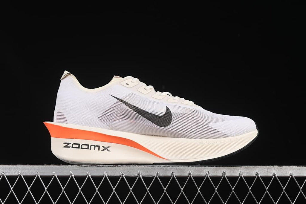 Side profile showing the white upper, black Swoosh, and orange midsole accent