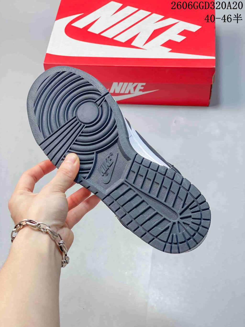 Underside view showing the dark patterned outsole of a Nike Dunk Low Retro sneaker