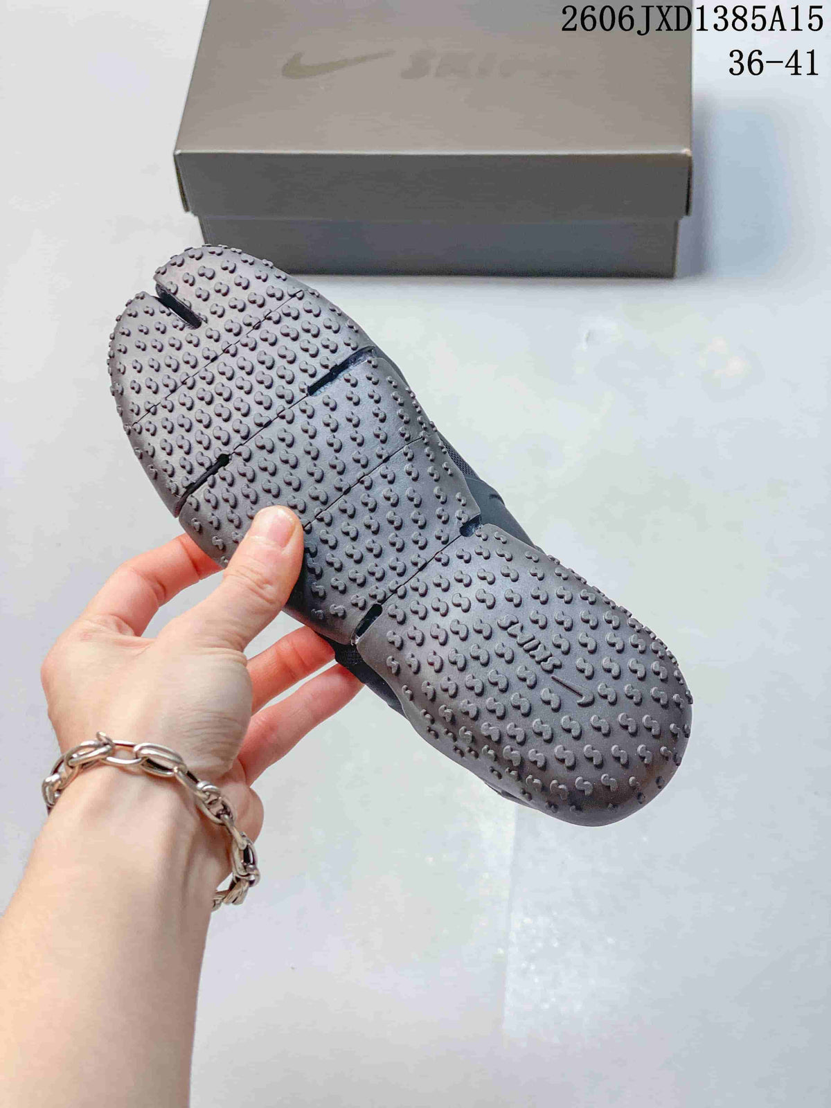 Close-up of the textured sole with raised traction pods on a dark gray Nike Air Rift shoe.
