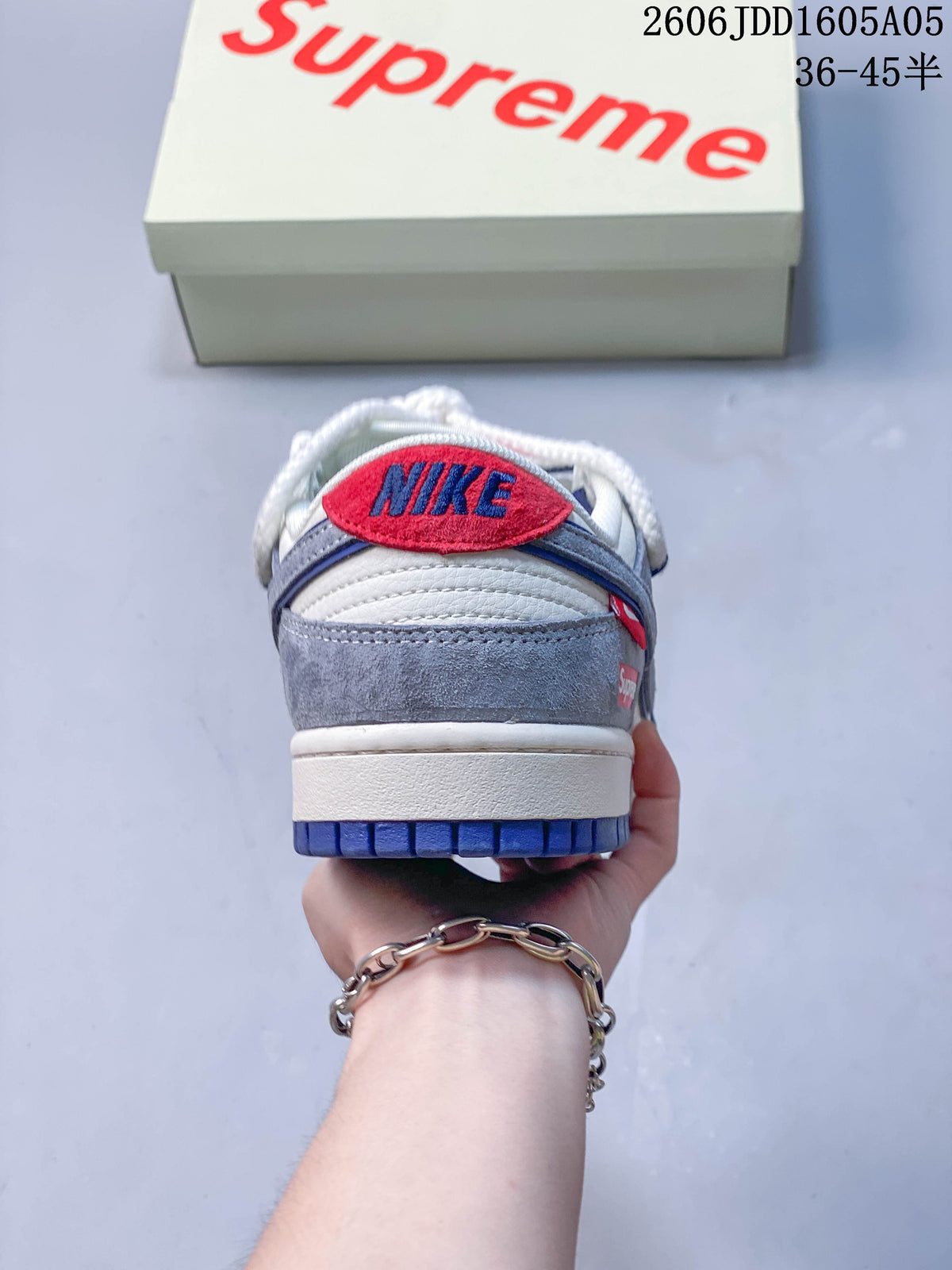 Rear view of a sneaker showing gray and white panels, blue outsole, and red heel detail