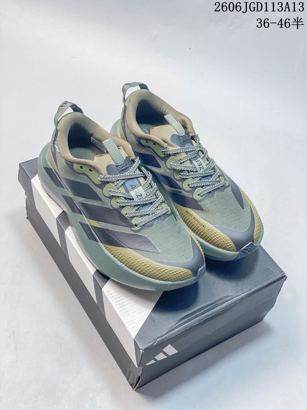 Pair of olive, gray, and muted yellow Adidas Adizero Evo SL ATR running shoes on a shoe box