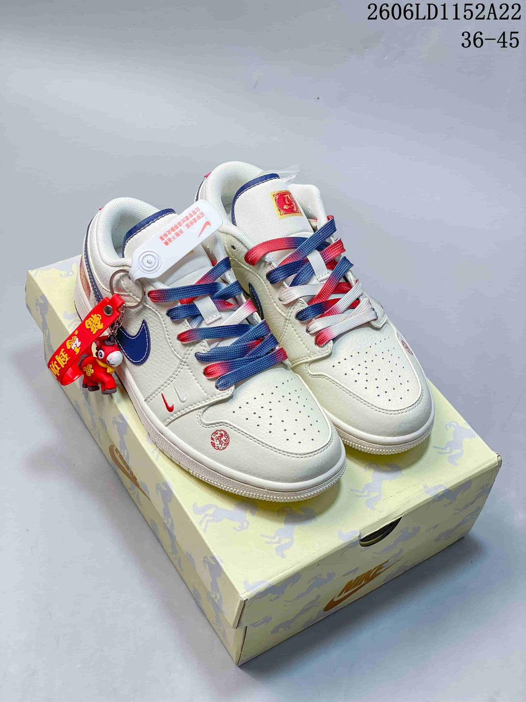Pair of white, blue, and red Air Jordan 1 Low sneakers displayed on a patterned box