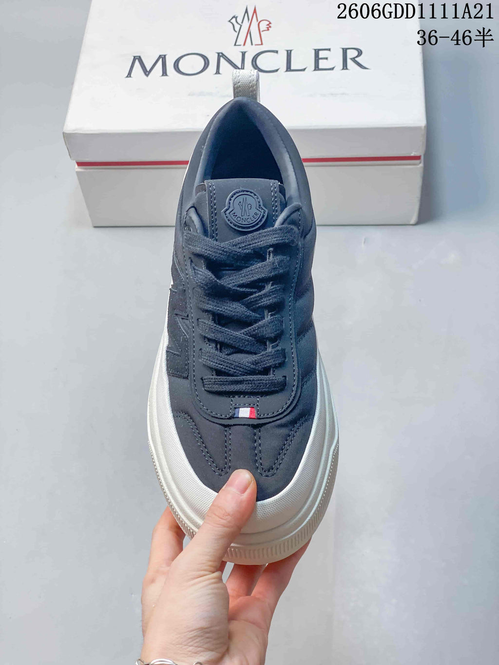 Top view of a navy lace-up sneaker with a rounded toe and white trim