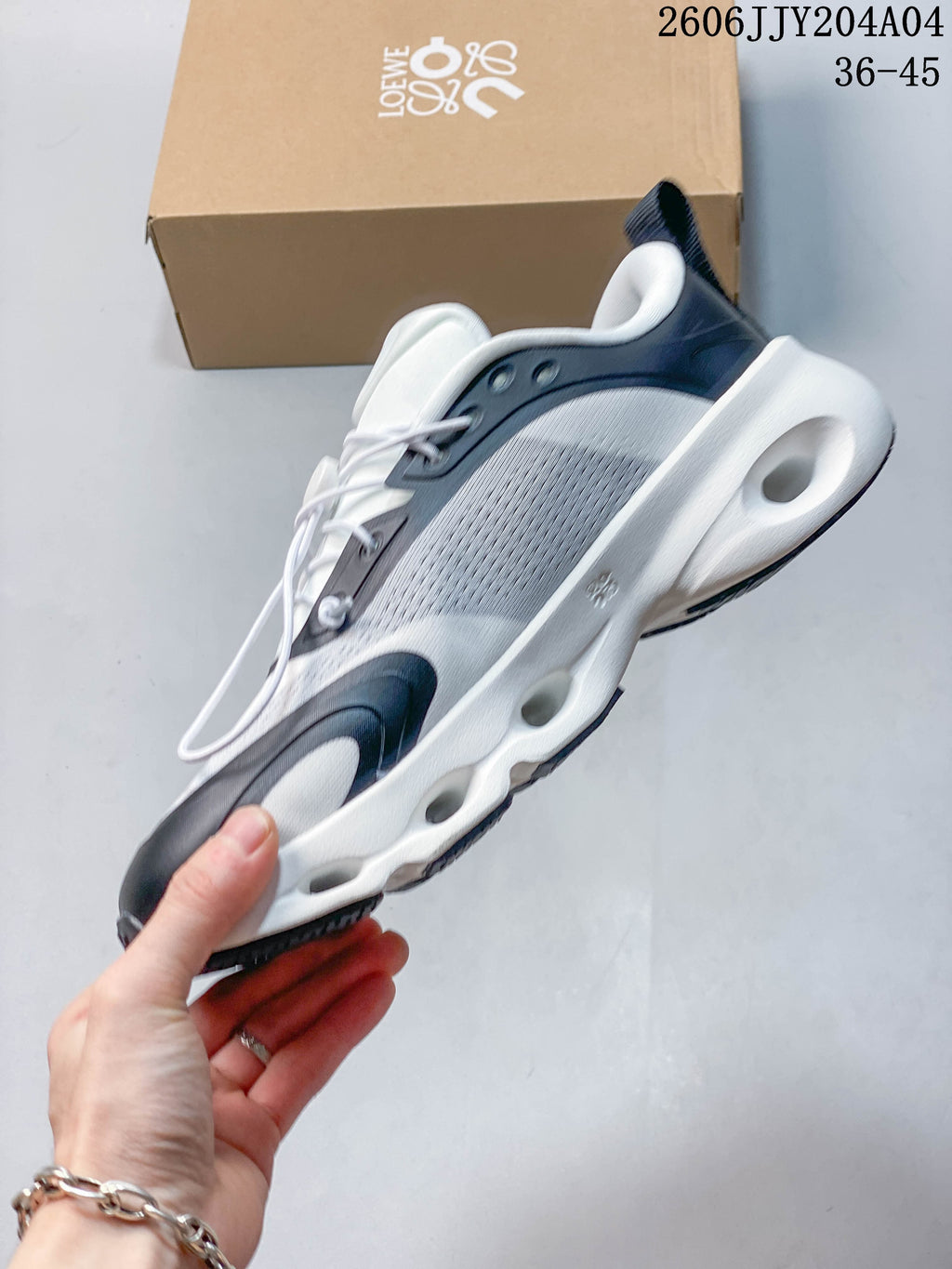 Side view of a white and navy sneaker with a sculpted sole