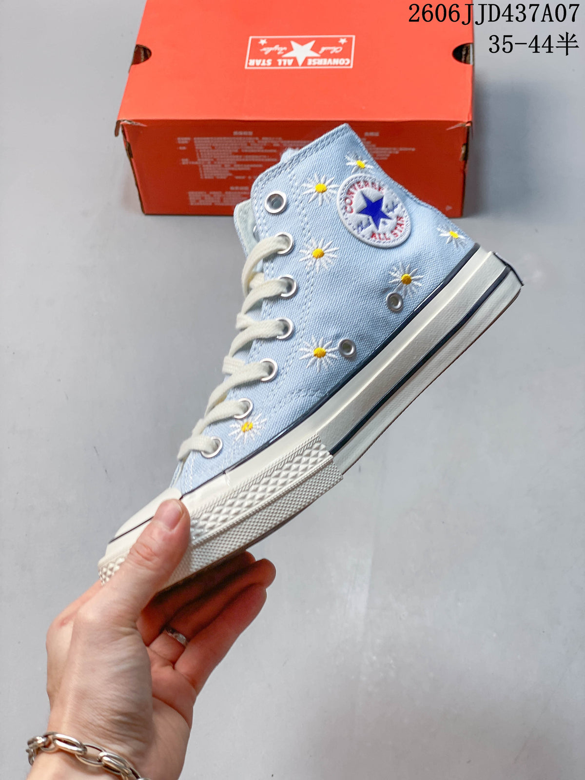 Side view of the light blue sneaker with daisy embroidery and a Converse ankle patch