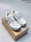 Pair of white On Cloudmonster sneakers with gray details, shown on a box