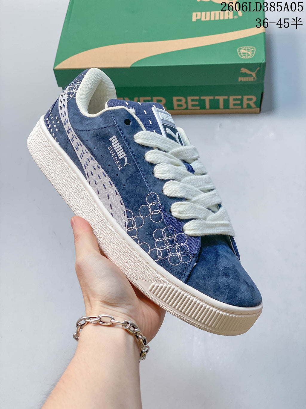Angled side view of a blue PUMA Suede XL sneaker with embroidered detailing and white laces.