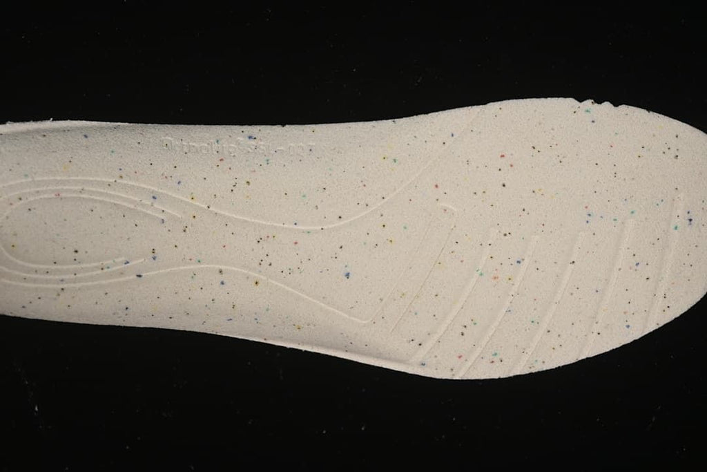 Close-up of a light-colored shoe insole with multicolored speckles