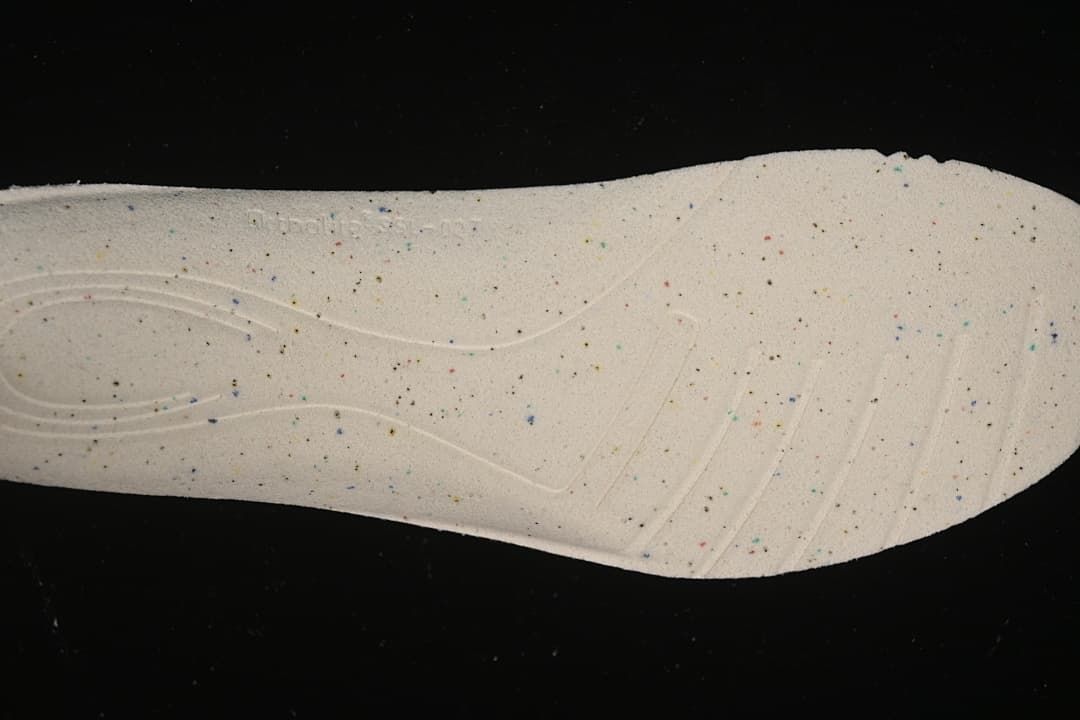 Close-up of a light-colored shoe insole with multicolored speckles