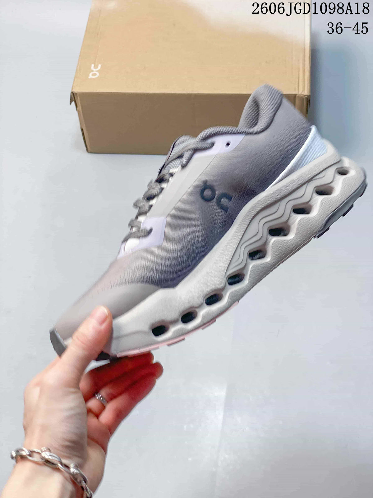 Side profile of a gray and pale pink Cloudmonster 3 sneaker