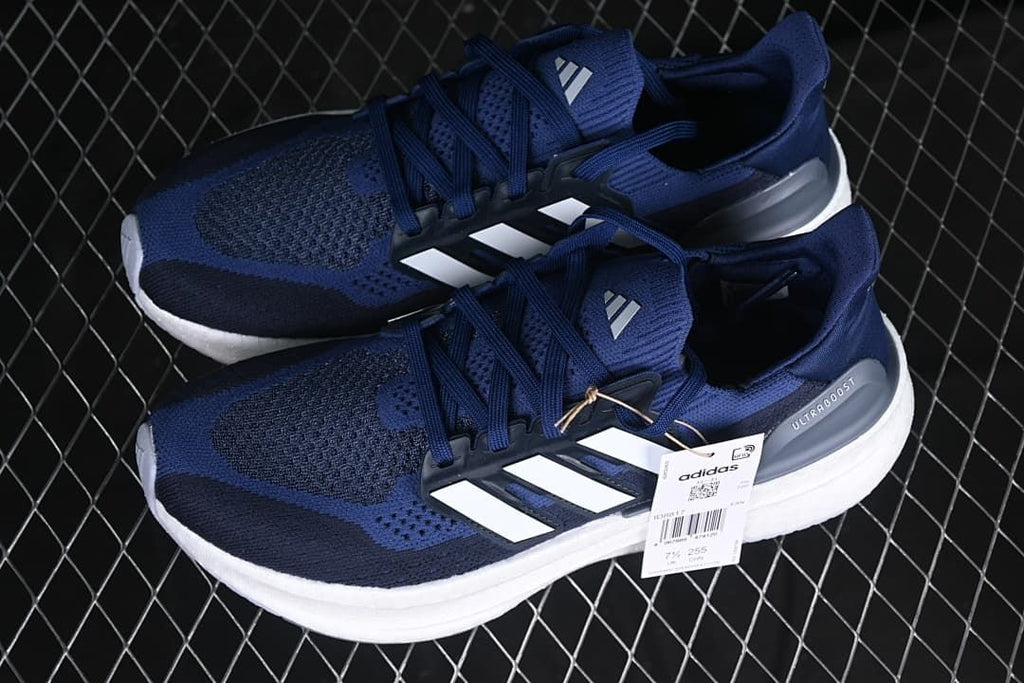 Pair of blue adidas Ultraboost 5 shoes with white stripes.