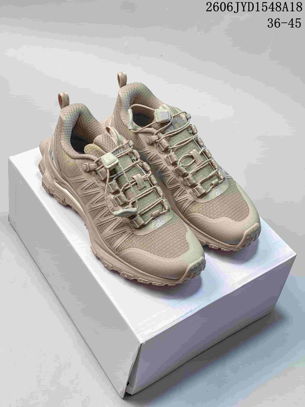 Pair of taupe Alo Yoga Trail running shoes shown from above at an angle.