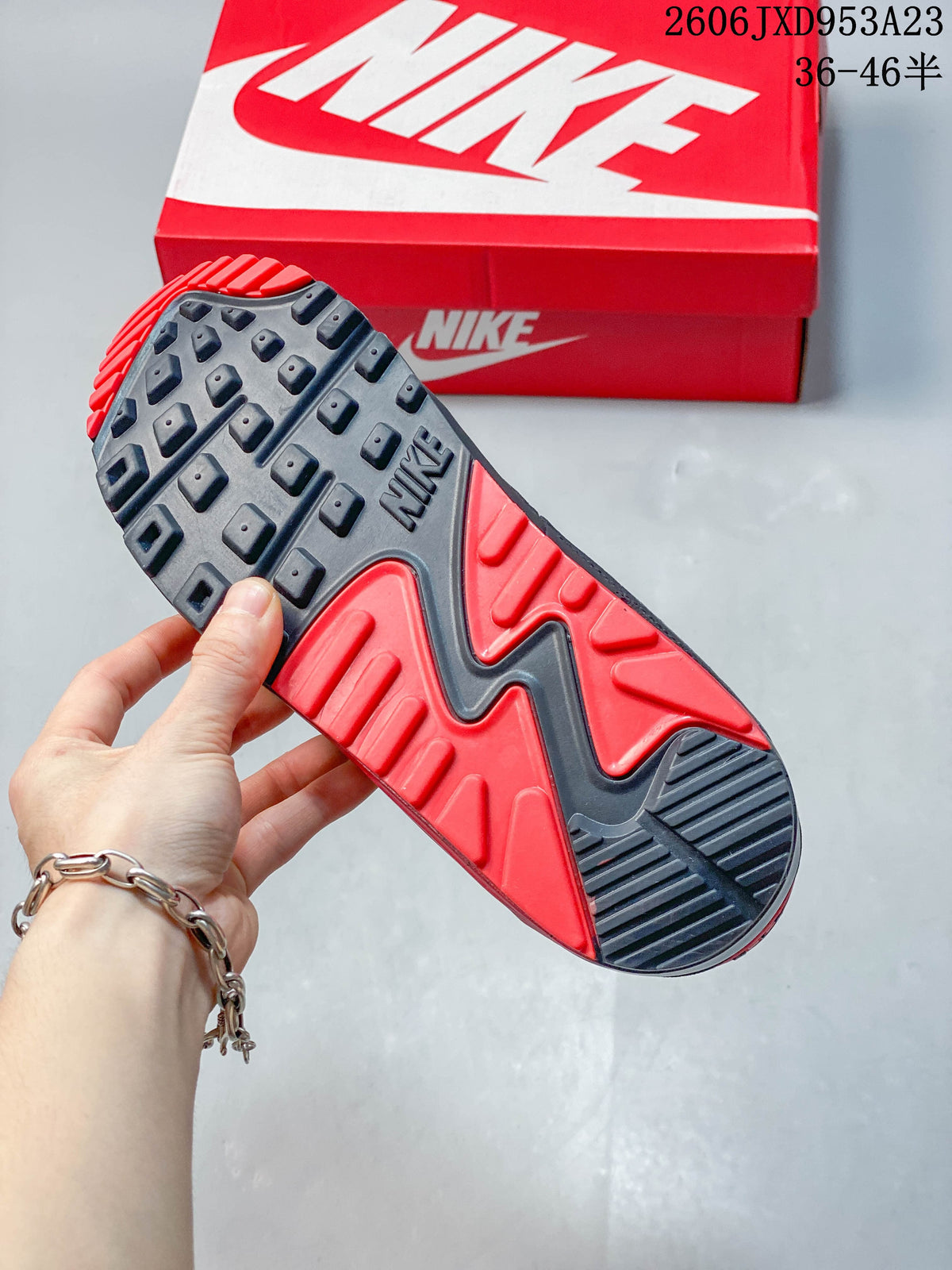Outsole of a gray and red Nike Air Max 90 sneaker