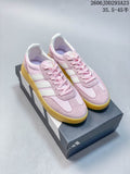 Pair of pink Adidas Barreda Decode sneakers with white stripes and a yellow-toned sole.