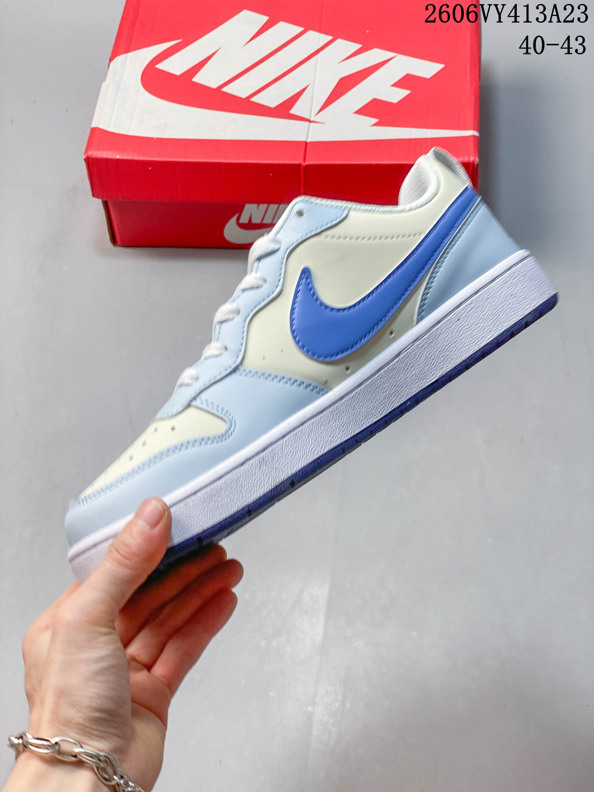 Side view showing the blue Swoosh and light blue panels on a NikeCourt Borough 2 Low sneaker