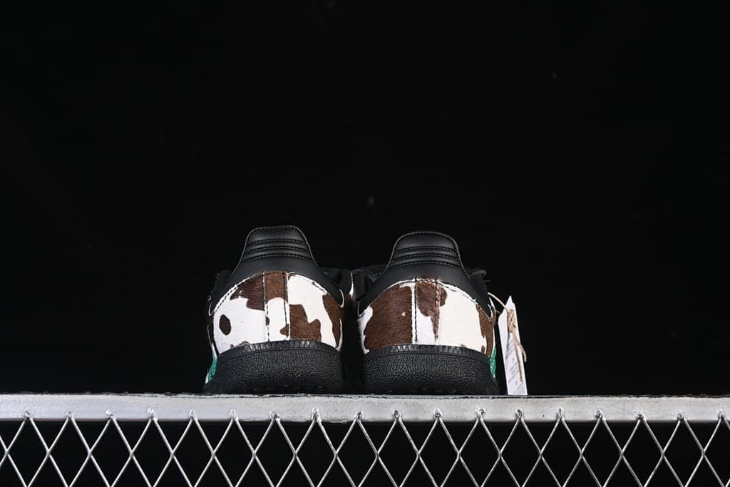 Rear view of both shoes showing cow-print heel panels and black heel counters