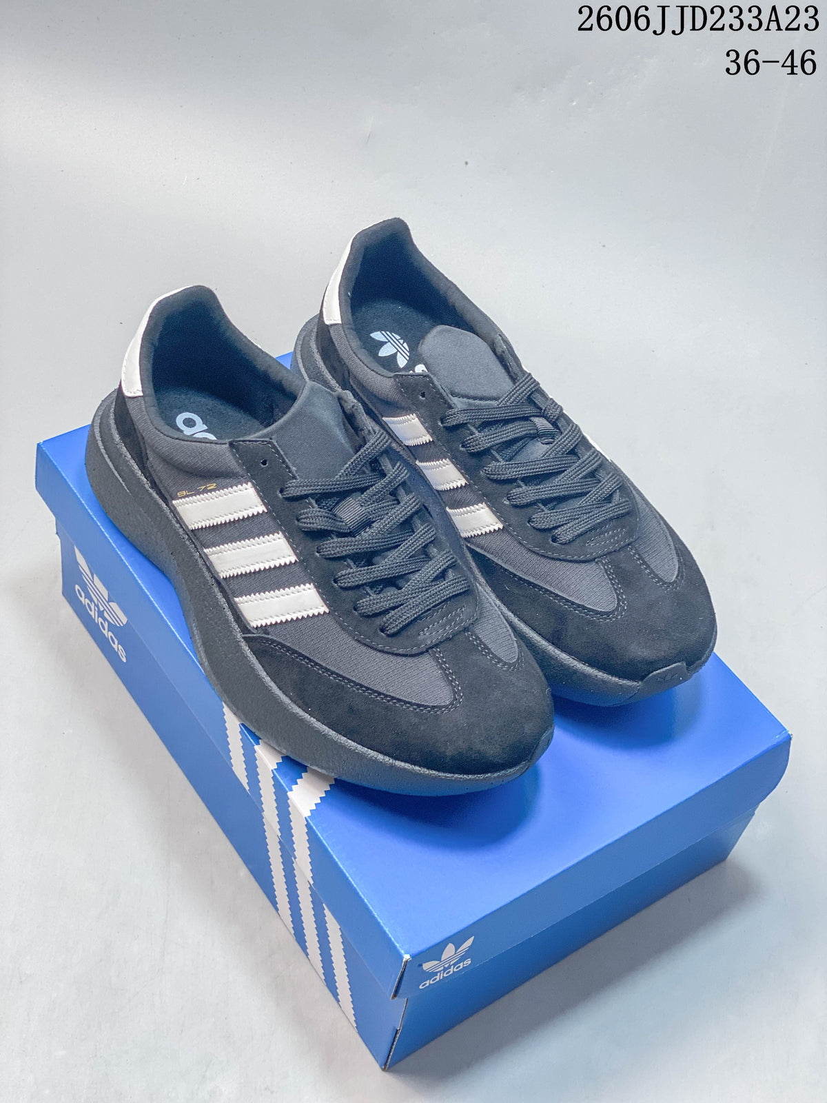 Pair of grey and black adidas Originals SL 72 Pro sneakers with light-colored stripes on a blue shoe box.